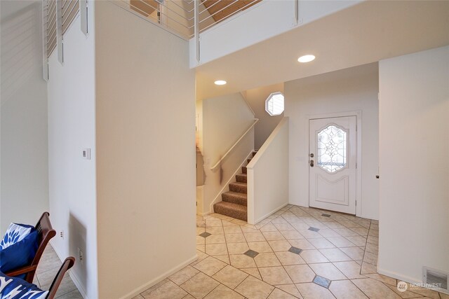 tiled entryway with a high ceiling