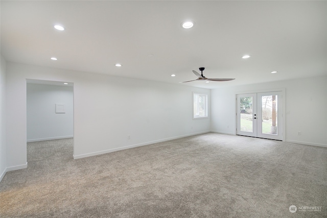 carpeted spare room featuring ceiling fan and french doors