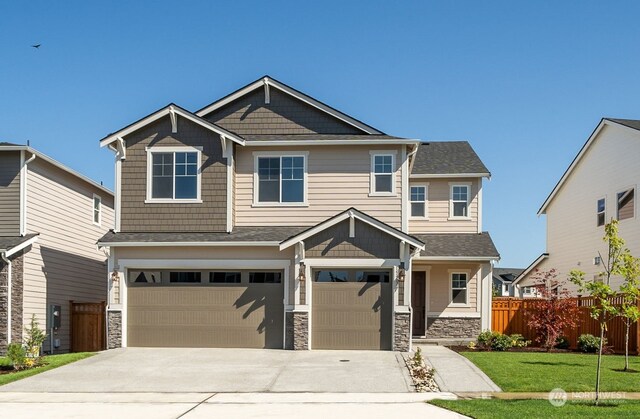 craftsman inspired home with a garage and a front lawn