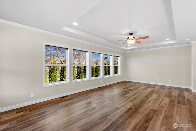 interior space with wood-type flooring, a tray ceiling, ceiling fan, and crown molding