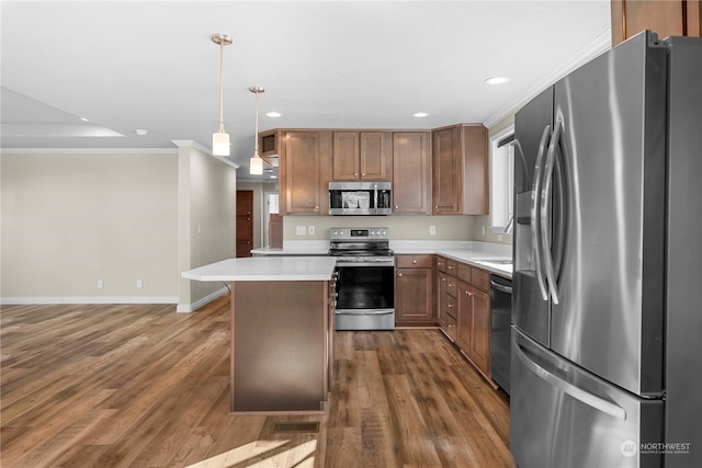 kitchen with ornamental molding, stainless steel appliances, decorative light fixtures, dark hardwood / wood-style floors, and a kitchen island