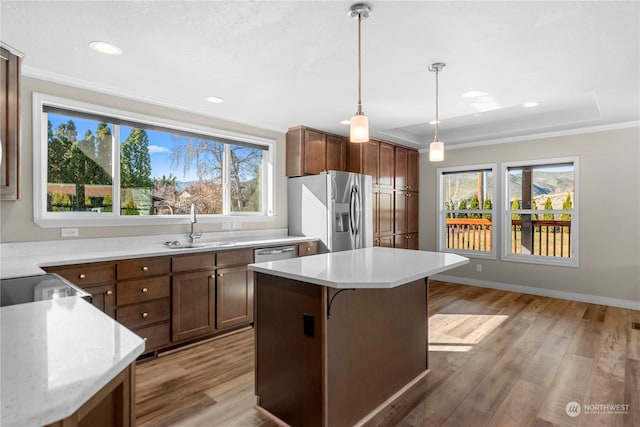 kitchen with stainless steel appliances, a kitchen island, and a wealth of natural light