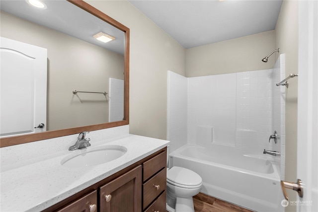 full bathroom featuring hardwood / wood-style floors, vanity,  shower combination, and toilet