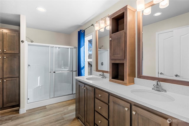 bathroom with a shower with door, vanity, and hardwood / wood-style flooring