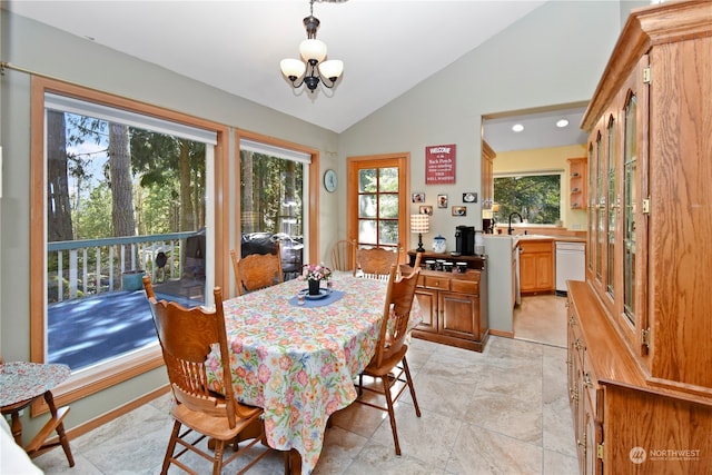 tiled dining area featuring sink, a chandelier, and vaulted ceiling