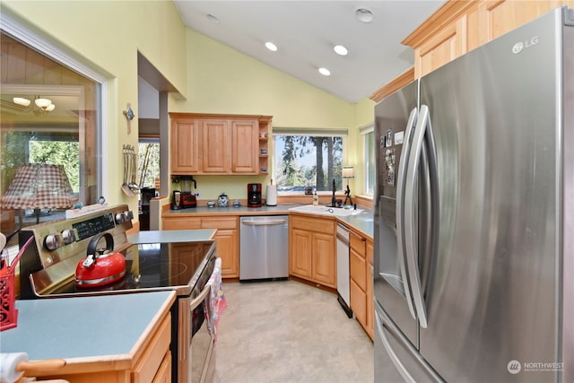 kitchen with an inviting chandelier, appliances with stainless steel finishes, light brown cabinets, high vaulted ceiling, and sink