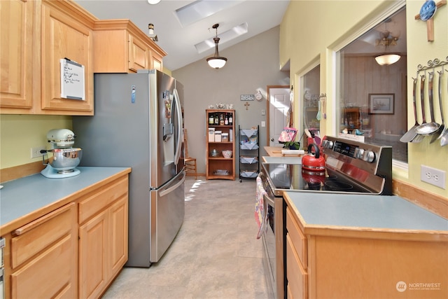 kitchen with light brown cabinets, light tile floors, stainless steel appliances, pendant lighting, and vaulted ceiling