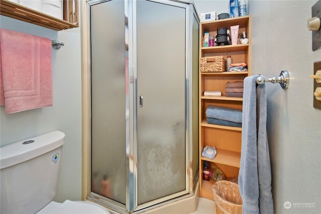 bathroom with toilet and an enclosed shower