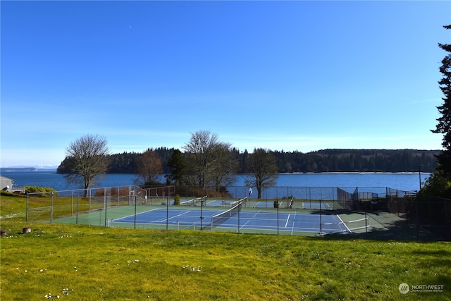 view of tennis court with a water view