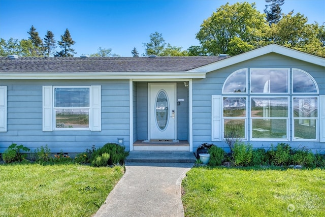 property entrance featuring a lawn