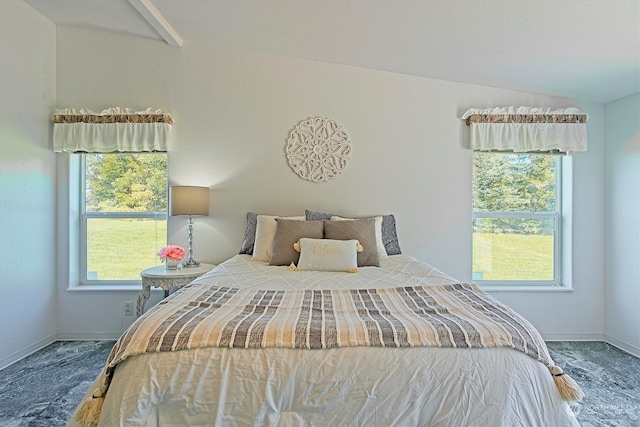 carpeted bedroom with lofted ceiling