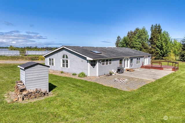 rear view of house featuring a patio area, a shed, and a lawn