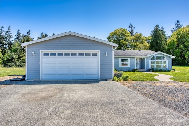 ranch-style home featuring a garage and a front lawn