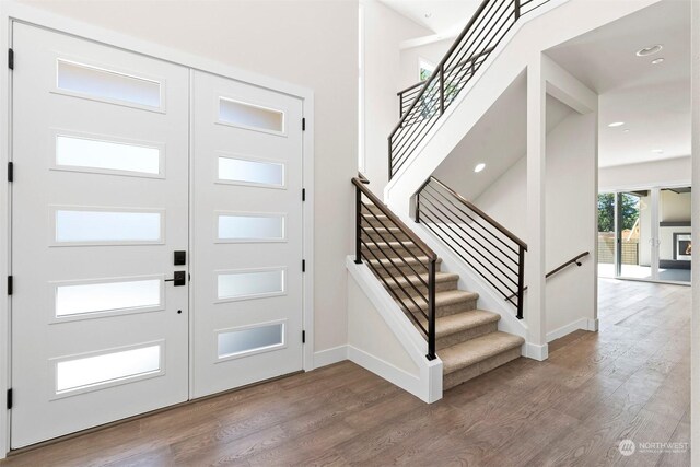 entryway featuring french doors, hardwood / wood-style floors, and a high ceiling