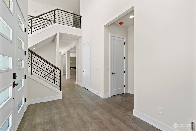 entrance foyer featuring dark wood-type flooring and a towering ceiling