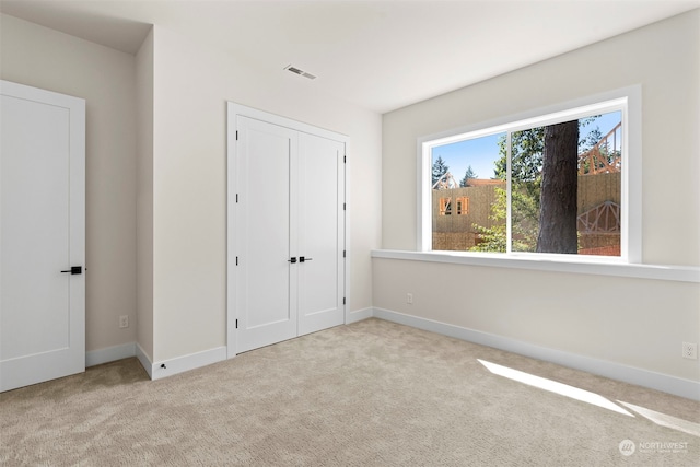 unfurnished bedroom featuring light carpet