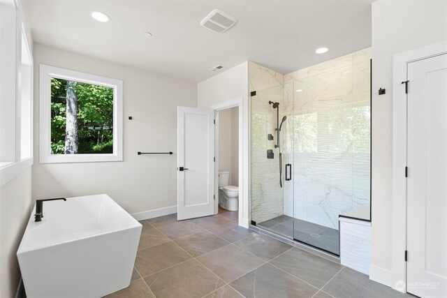 bathroom featuring toilet, separate shower and tub, and tile patterned flooring