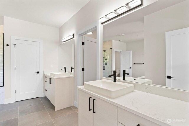 bathroom with tile patterned flooring and dual bowl vanity