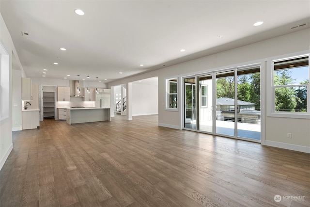 unfurnished living room featuring sink and dark wood-type flooring