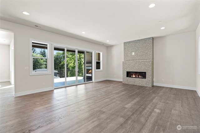 unfurnished living room featuring a fireplace and wood-type flooring