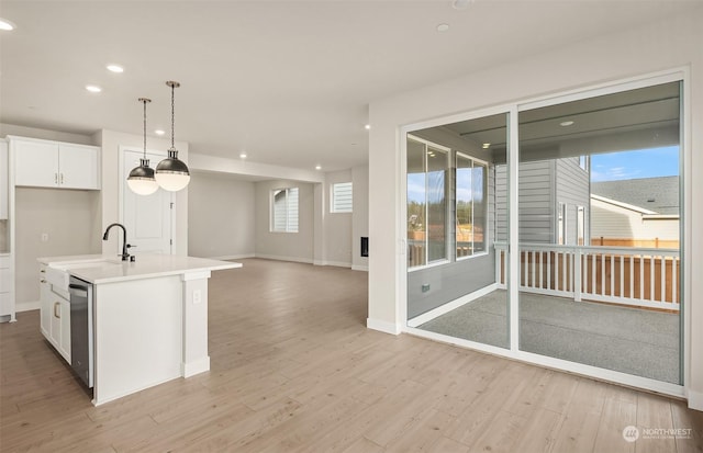 kitchen with white cabinetry, sink, a center island with sink, and light wood-type flooring