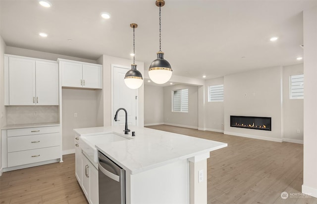 kitchen with white cabinets, hanging light fixtures, dishwasher, and a center island with sink