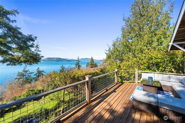 deck featuring a water view and outdoor lounge area