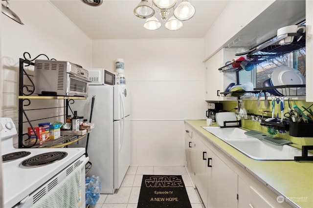 kitchen with light tile floors, an inviting chandelier, white appliances, white cabinets, and sink