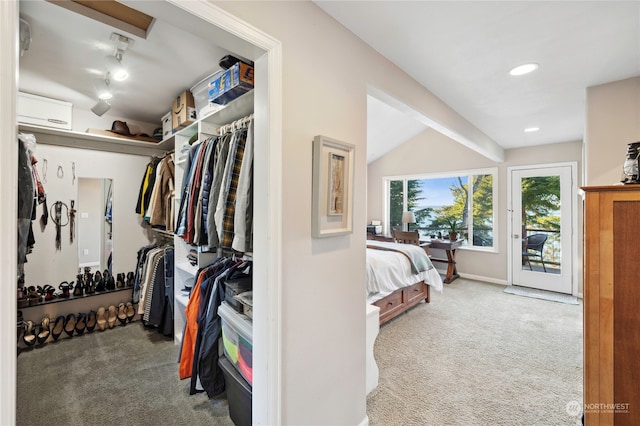 spacious closet featuring lofted ceiling with beams, a wall mounted air conditioner, and light colored carpet