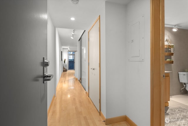 hall featuring electric panel and light hardwood / wood-style flooring