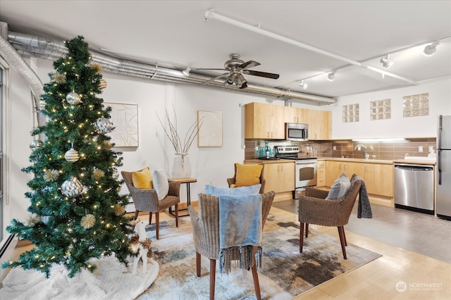 living room with ceiling fan and sink