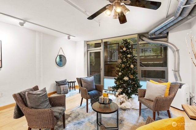 living room with track lighting, light hardwood / wood-style flooring, and ceiling fan