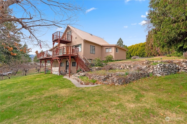 back of house with stairway, a deck, and a lawn