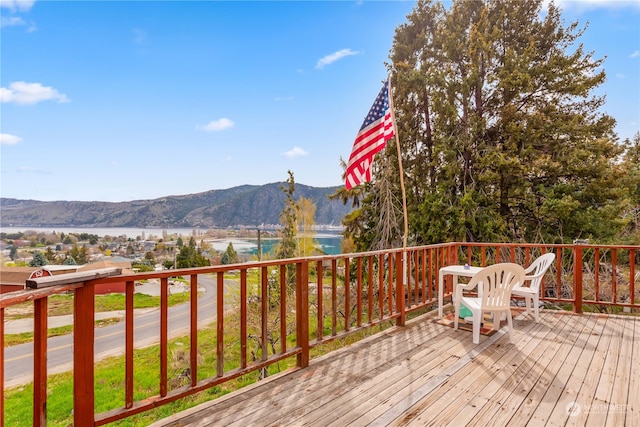 wooden terrace featuring a water and mountain view