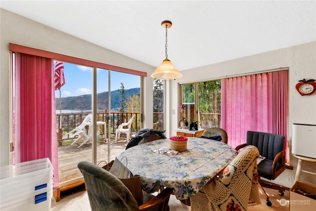 tiled dining space with a mountain view and lofted ceiling