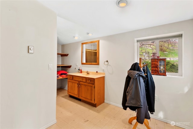 bathroom with vanity, baseboards, and tile patterned floors