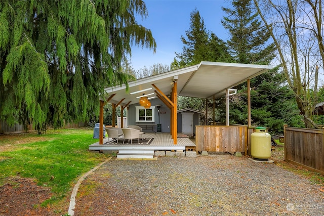 view of front of property featuring an outdoor structure, a deck, and a front lawn