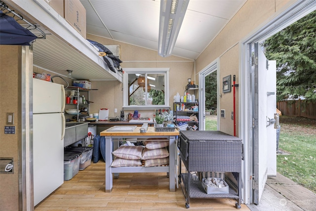 interior space with lofted ceiling and light hardwood / wood-style flooring