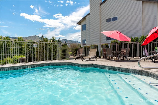 view of pool with a mountain view and a patio area