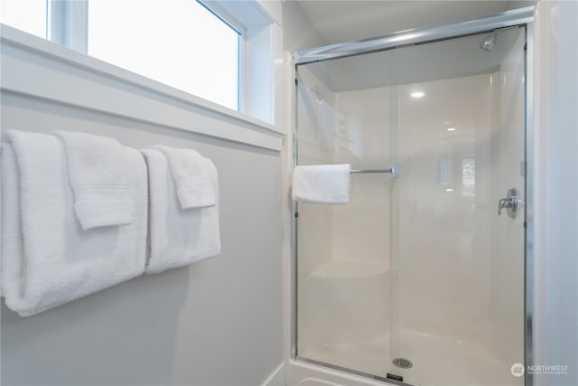 bathroom featuring a shower with door and plenty of natural light