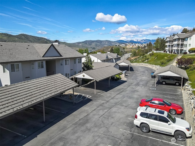 view of parking with a mountain view and a carport