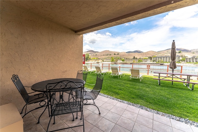 view of terrace featuring a water and mountain view