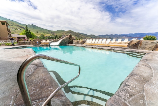 view of swimming pool with a mountain view and a water slide