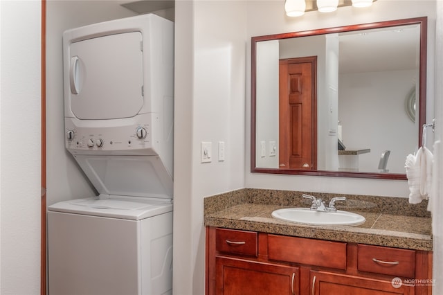 clothes washing area featuring stacked washer / drying machine and sink