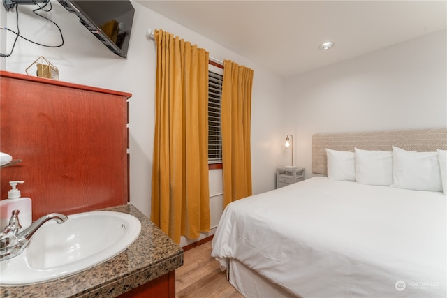 bedroom with light hardwood / wood-style floors and sink