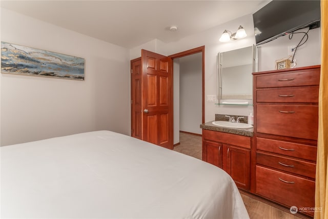 bedroom with sink and light hardwood / wood-style floors