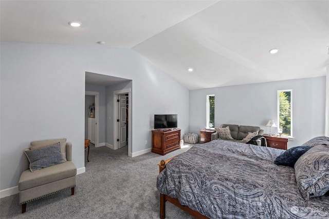 bedroom with a walk in closet, a closet, carpet floors, and lofted ceiling