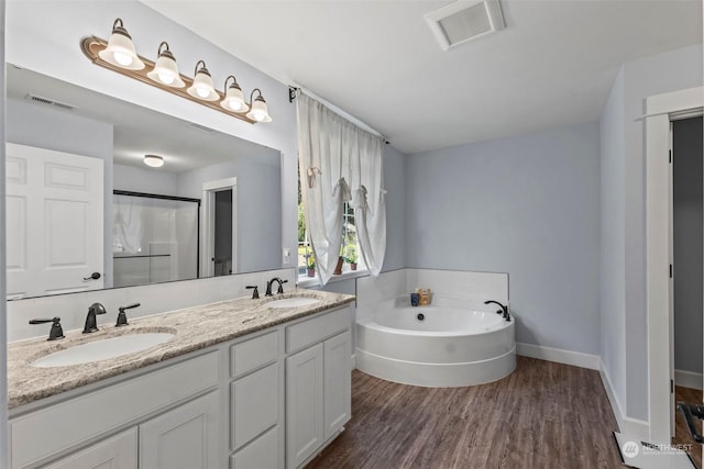 bathroom featuring vanity, hardwood / wood-style flooring, and separate shower and tub