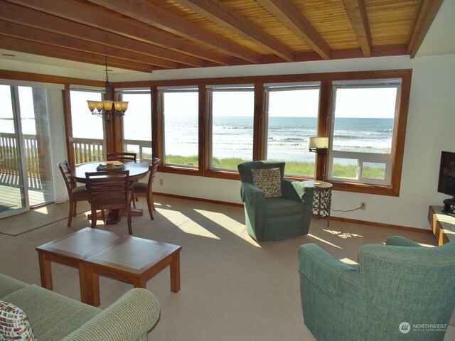 interior space with a chandelier, a water view, wood ceiling, and beamed ceiling