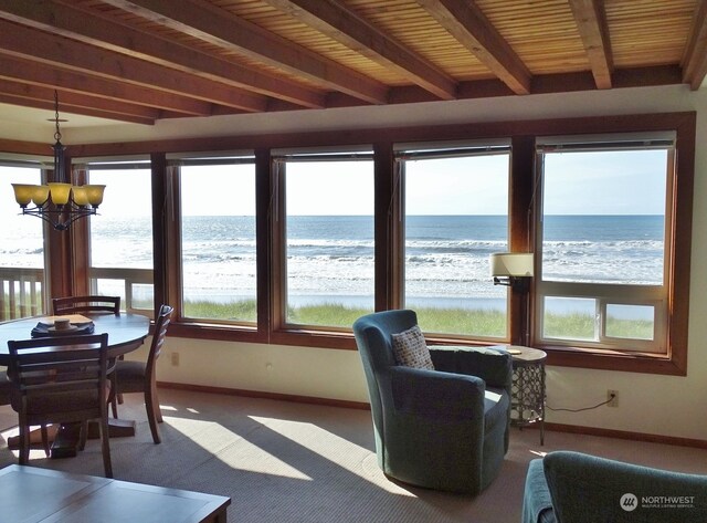 sunroom with an inviting chandelier, a water view, beamed ceiling, and wood ceiling